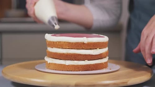 The Pastry Chef Applies the Cream to the Berry Layer Between the Biscuits