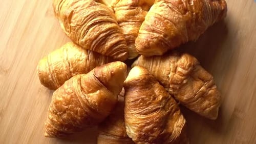 Golden Croissants Arranged Overhead on Wooden Surface