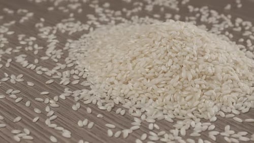 Heap of White Rice Grains on Wooden Table