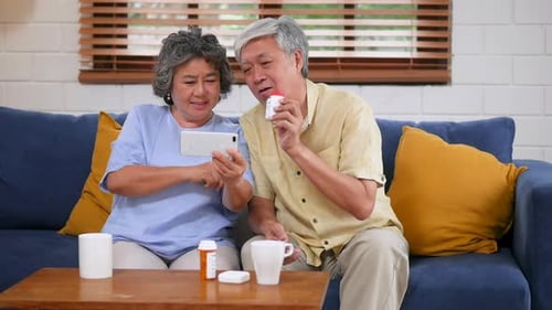 Senior Couple Discussing Medication at Home with Smartphone