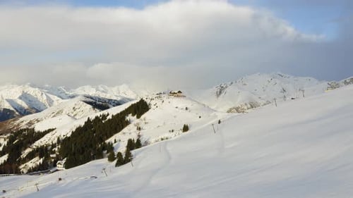 Approach Aerial View of Snow Covered Mountain Range. Winter Wild Nature outdoor.Blue Sky with Clouds