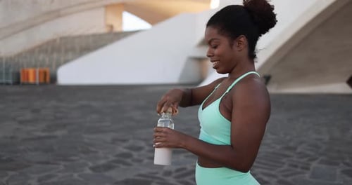 Athletic Woman Drinking Water after Exercise