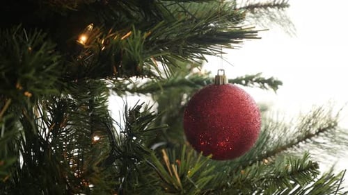 Festive Red Ornament on Christmas Tree with Lights