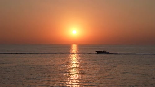 Sunset Over Ocean with Boat Passing By