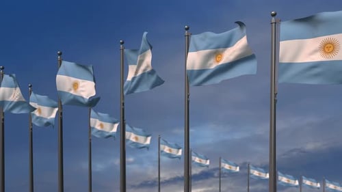 Multiple Argentinian Flags Waving on Flagpoles Against Blue Sky