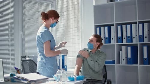 Medical Professional Giving Vaccine to Young Adult Patient