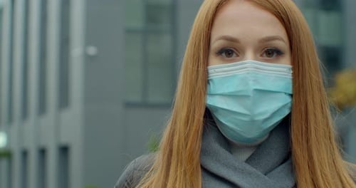 Close Up Portrait of a Beautiful Redhead Young Woman Wearing Protective Medical Face Mask and