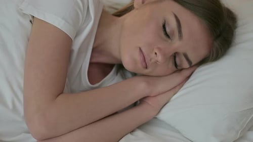 Young Woman Sleeping Peacefully in Bed at Home