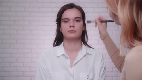 Makeup Artist Applying Cosmetics to Model's Face