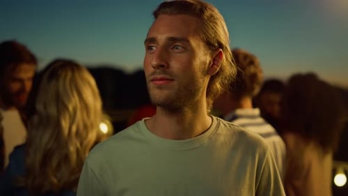 Smiling Man at Outdoor Social Gathering at Night