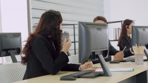 Geschäftsleute mit Headset, die im Büro arbeiten