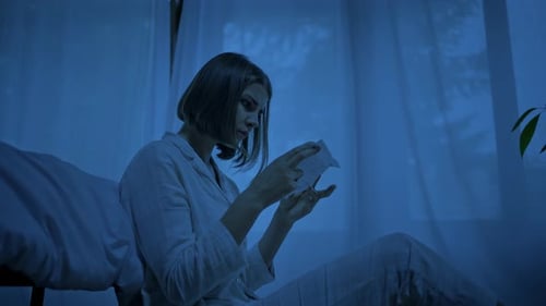 Sleepless Woman Reads Instructions for Sleeping Pills