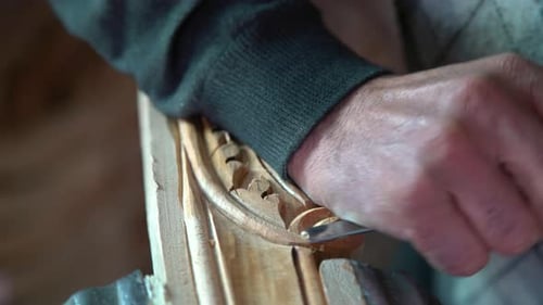 Artist Carving Wood Ornament with Chisel Tool