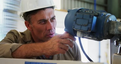 Engineer Inspecting Machinery With Tablet in Factory