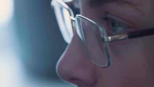 Eyes of a Teenager in Glasses Closeup His Eyes Run Around the Computer Monitor