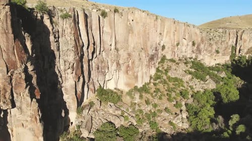 Aerial Deep Long Rift Canyon with Cleft Steep Rock Walls and High Cliff Gorge