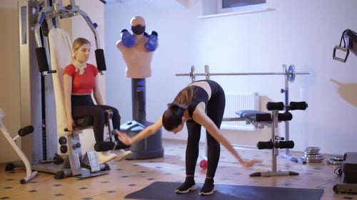 Wide Shot Portrait of Slender Concentrated Sportswoman Bending Forward in Gym with Focused