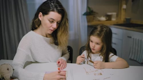 Woman and Child Drawing Together Indoors at Table
