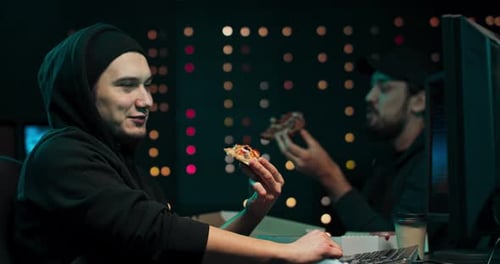 Young Adults Eating Pizza at Computer Workplace