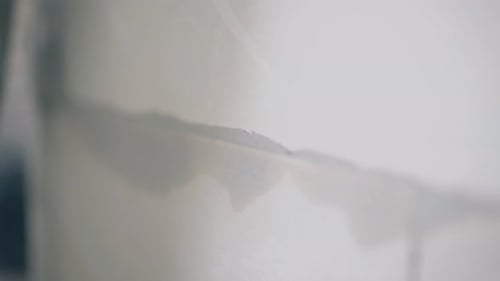Plasterer Smears Excess Glue on White Gypsum Pasteboard