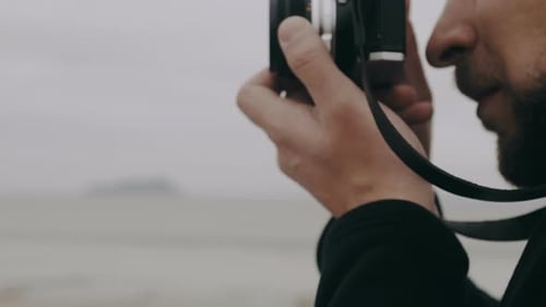 Close-up Side View Caucasian Photographer Man Taking Picture with Old Fashioned Film Camera on