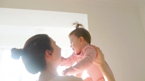 Smiling Baby Lifted By Smiling Woman