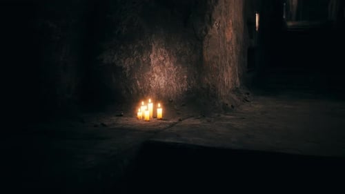 Glowing Candles in a Dark Cave with Flickering Light