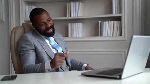 Professional Man in Suit Video Conferencing on Laptop
