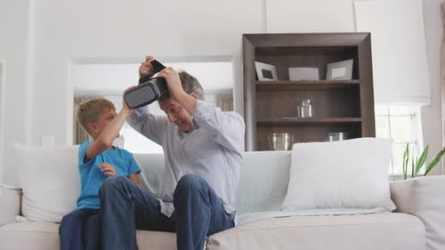 Boy Helps Adult With Virtual Reality Headset