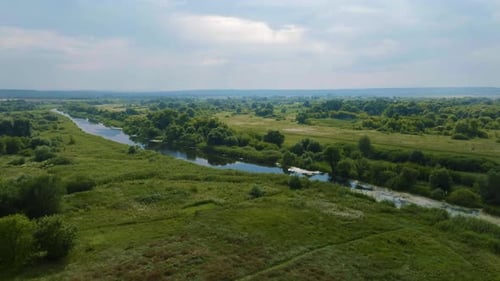 Top View of Green Fields Hills Trees and River Bed