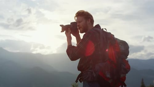 Photographer Hiker Taking Pictures of Majestic Mountains at Sunset