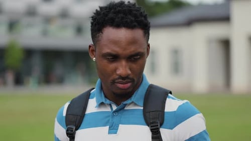 Young Male Person with Bag on Shoulder Smiling While Standing at City Street