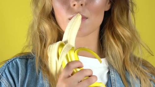 Young Woman Eating a Banana Close Up