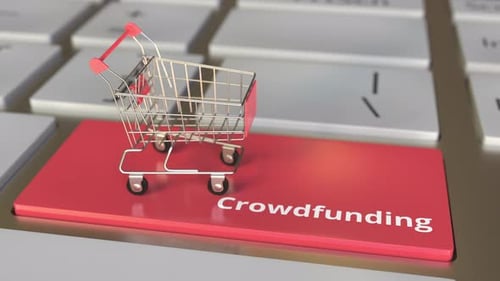 Crowdfunding Text on Keyboard and Boxes in Shopping Cart