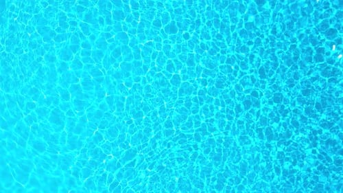 Blue Water in the Swimming Pool with Light Reflections