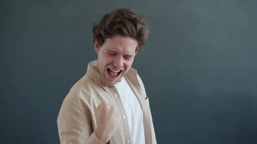 Young Man Celebrates Success with Raised Fists