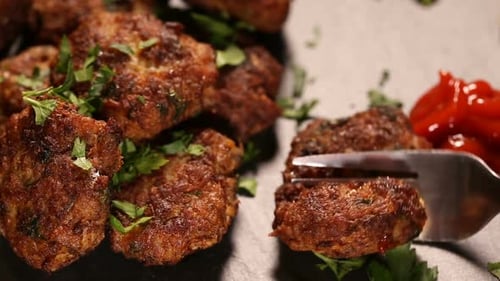 Meatball Pierced with Fork beside Tomato Sauce