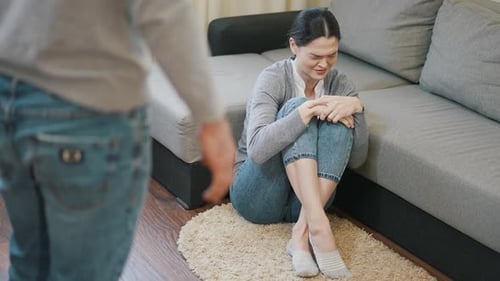 Distressed Woman Sitting on Floor Next to Couch