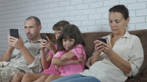 Family Using Smartphones Together on Couch