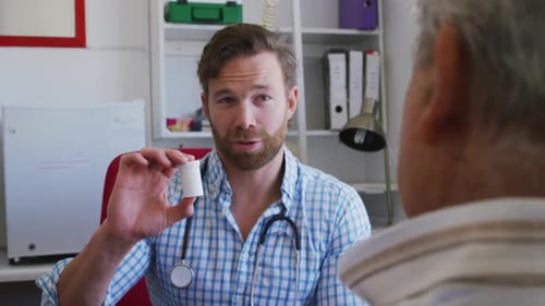 Male Doctor Explaining Medication to Patient in Office