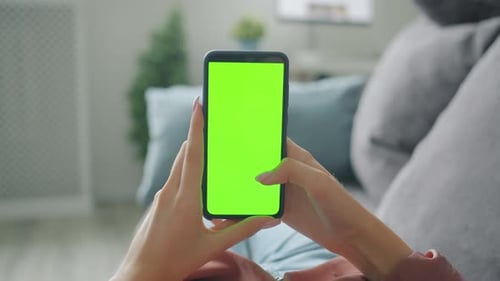 Slow Motion of Lady's Hand Touching Mock-up Green Smartphone Screen at Home