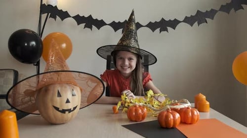 Girl Smiles in Halloween Decorated Room
