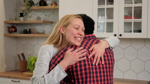 Friends Embracing in a Cozy Home Kitchen