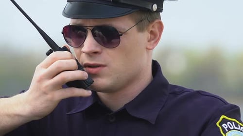 Law Enforcement Officer Communicating on Radio Device