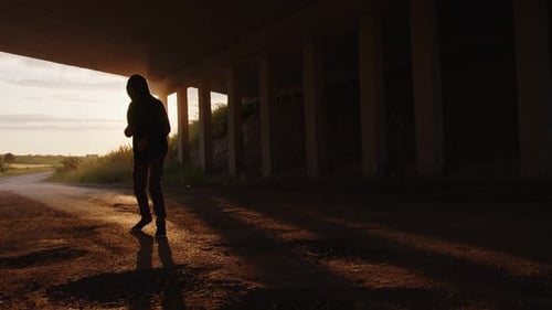 Silhouette of Man Boxing Under Bridge During Sunrise