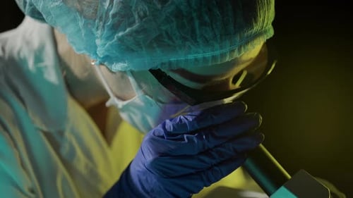 Scientist Inspects Sample Through Microscope in Lab