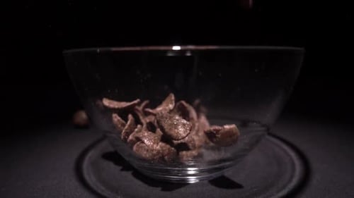 Chocolate Cereal Falling into Clear Bowl