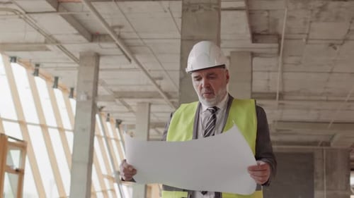 Foreman Walking in Building with Plan
