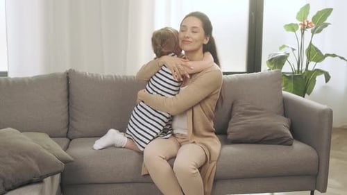 Loving Mother and Child Embrace on Sofa