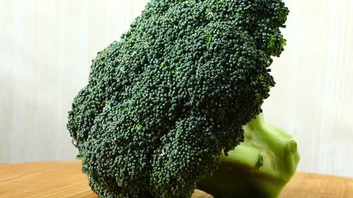 Fresh Broccoli Rotating on Wooden Surface